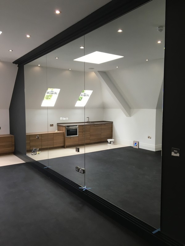 Frameless glass partition in loft conversion by Pinner glaziers